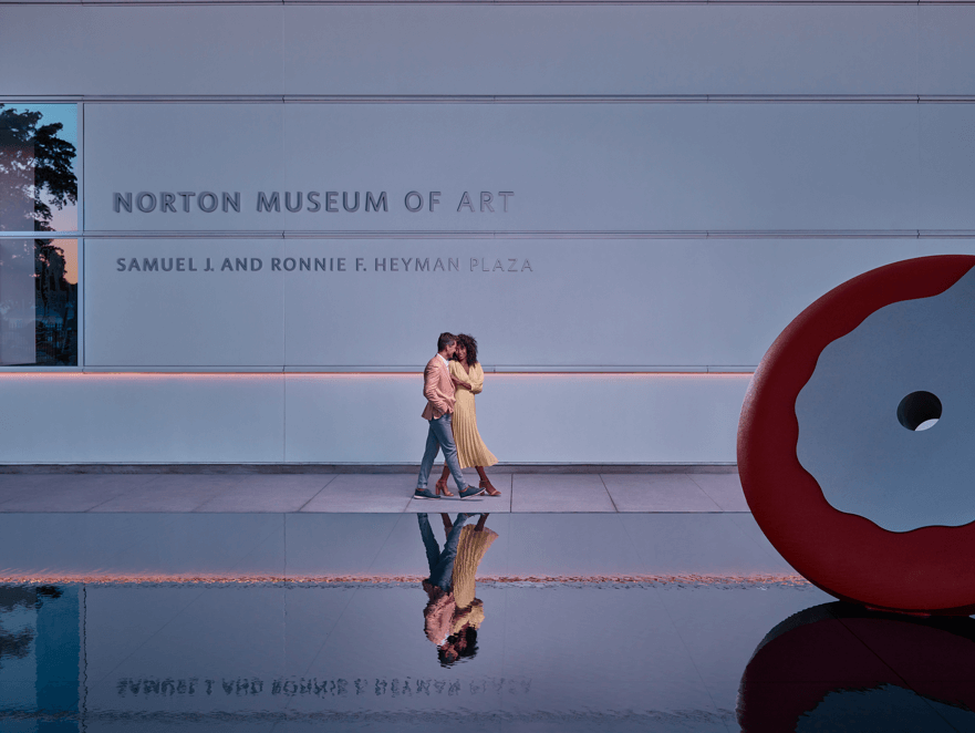 Um casal caminhando em frente ao Norton Museum of Art em West Palm Beach